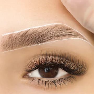 Close-up of a woman's face highlighting freshly microbladed eyebrows, with a focus on the natural, defined brow shape.